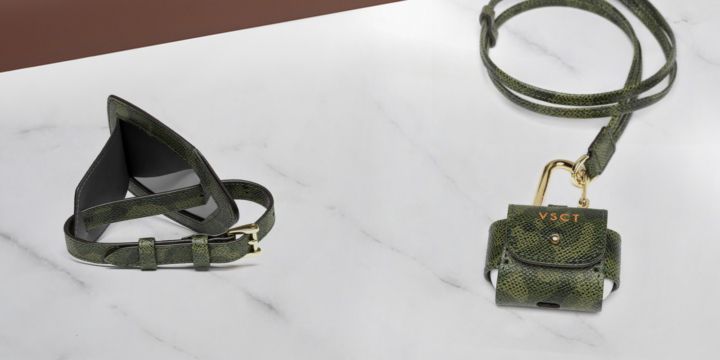 Cover Airpod e tag tag bagaglio in versione camouflage su superficie di marmo.