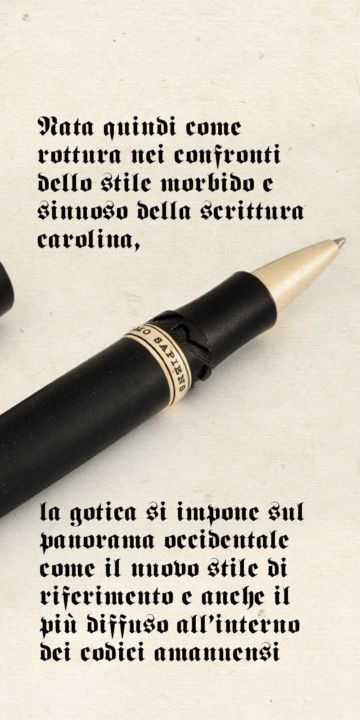 A black rollerball pen over a parchment with text in Gothic script.