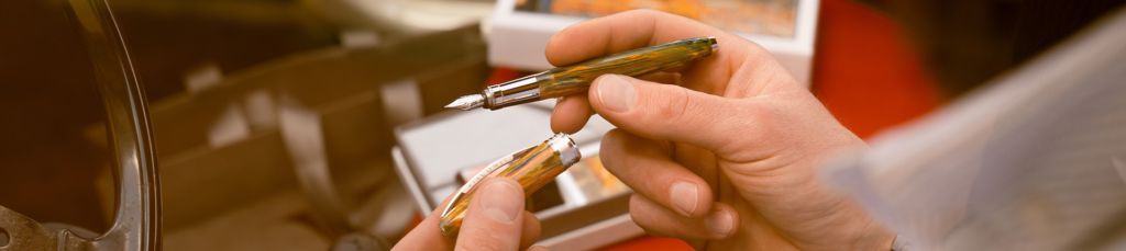 Una mano che regge una penna stilografica da collezione