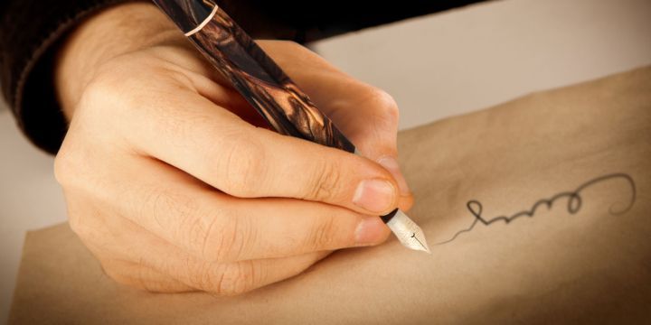 mano che scrive con la penna stilografica Medici golden black Visconti su pergamena