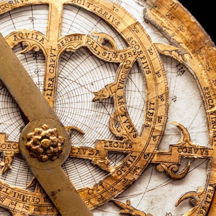Astrolabio antico di carta sopra mappa di navigazione