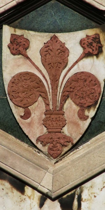 giglio di Firenze rosso ritagliato su scudo in pietra su sfondo di marmo verde