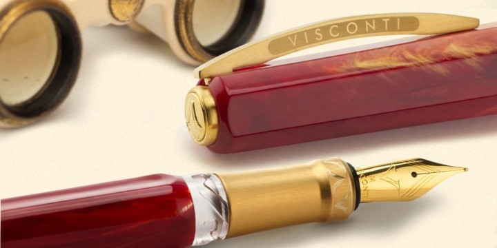 Opera Gold pen in red and gold version in front of opera binoculars