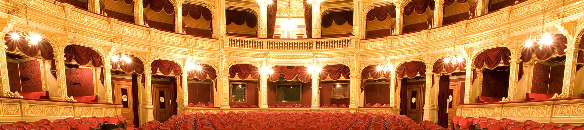 teatro con poltrone rosse e cornici d'oro